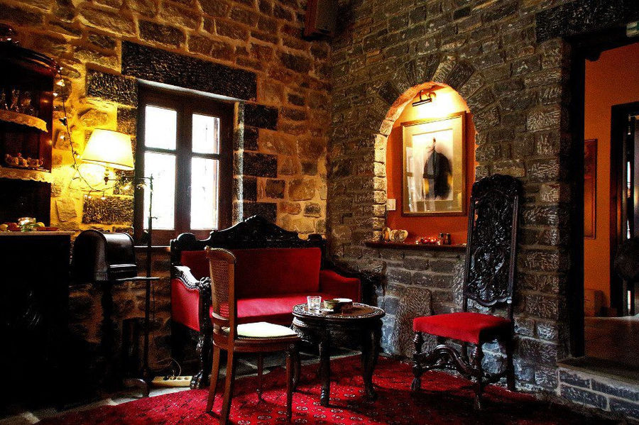 illuminated Kalogris Winery stone tasting room with folklore carpet and sofa with chairs